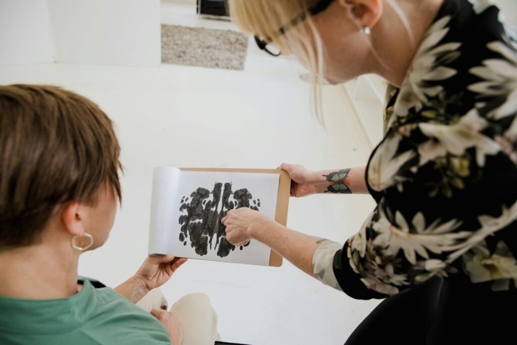 Therapist discussing Rorschach inkblot test with a client in a therapy session.